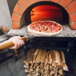 Chef in the kitchen prepares pizza