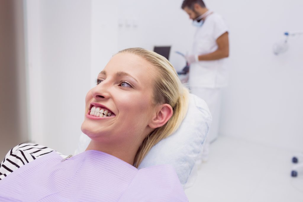 Woman showing her white teeth in clinic